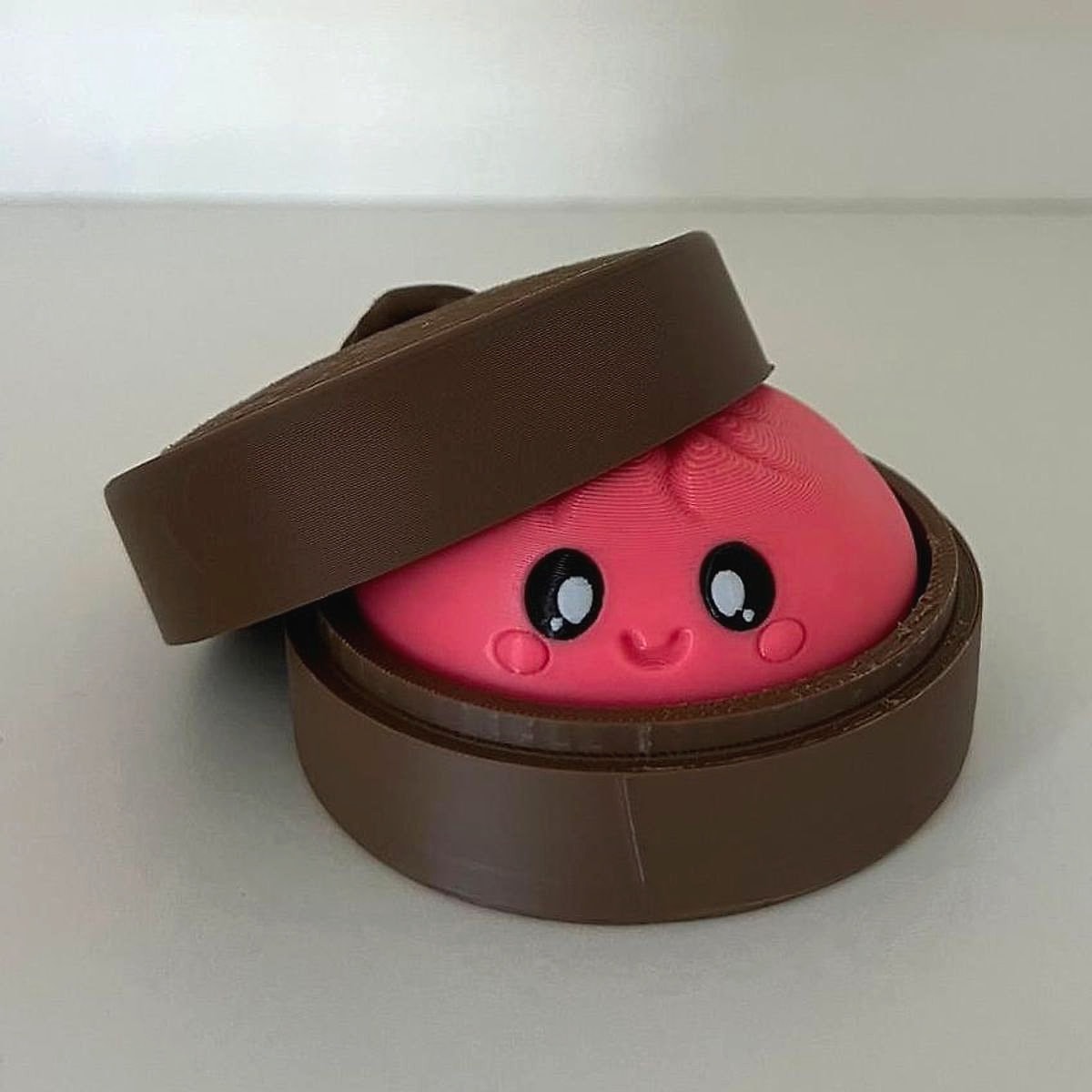 A pink bao bun figurine inside a brown steamer